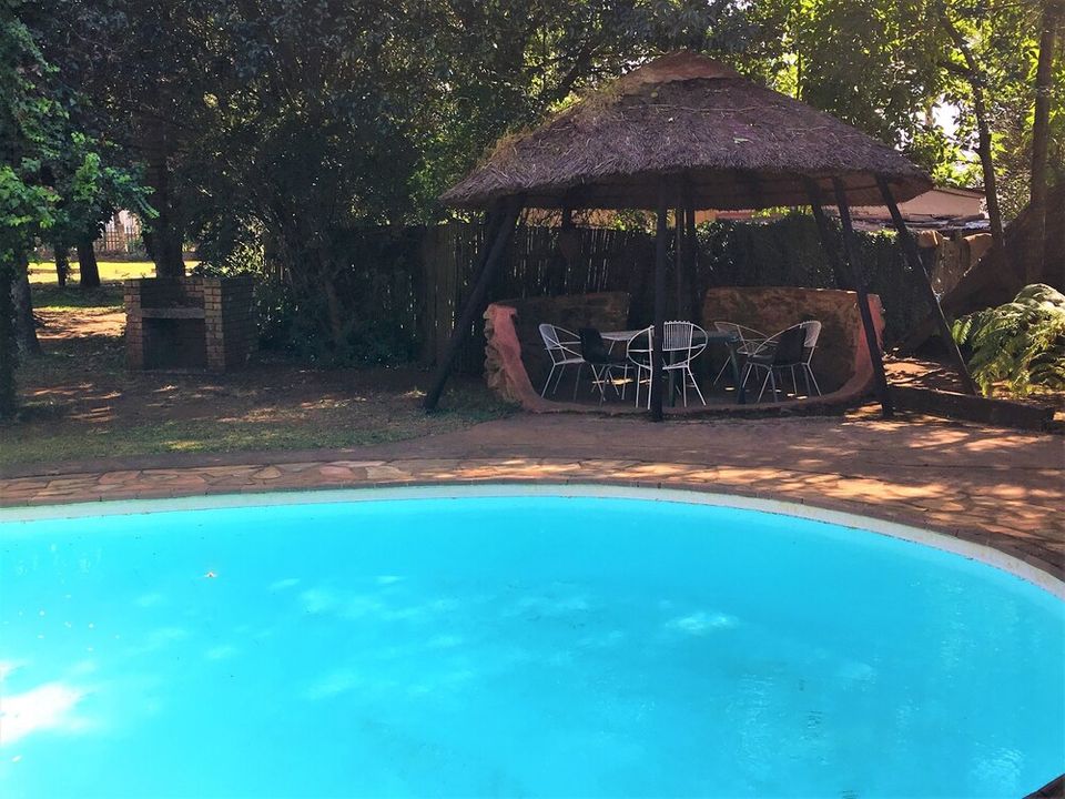 The swimming pool at Summit Lodge, with loungers on the surrounding lawn