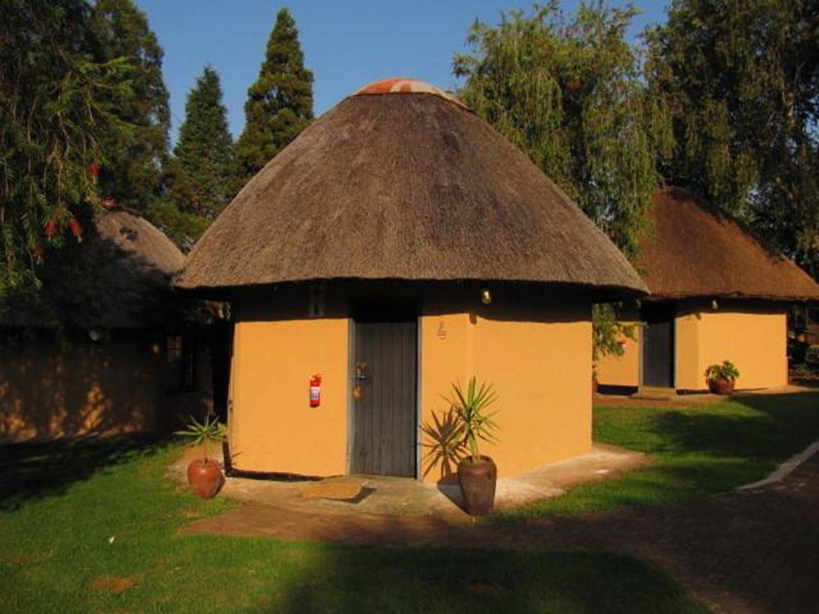 A thatched rondavel among the lodge gardens